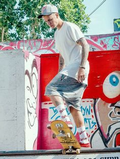 a man riding a skateboard down the side of a cement wall covered in graffiti