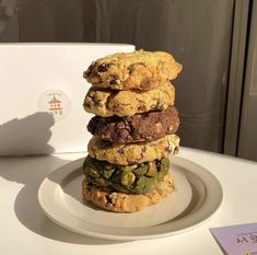 a stack of cookies sitting on top of a white plate next to a card board