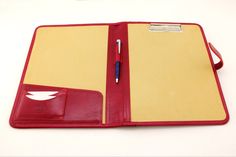 a red and yellow folder with a pen on it