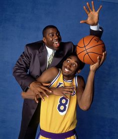 two basketball players posing for a photo with their arms around each other and one holding a basketball