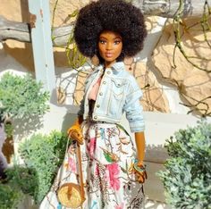 a doll with an afro holding a purse