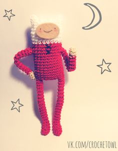 a crocheted doll hanging on the wall with stars and moon in the background