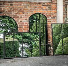 three mirrors sitting next to each other in front of a brick building with arched windows