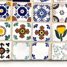 colorful tiles are arranged on the wall in different colors and designs, including flowers or leaves