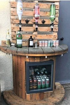 an outdoor bar made out of pallets with bottles and cans on the top shelf