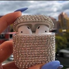 a person holding an airpods in their hand with the case made out of diamonds