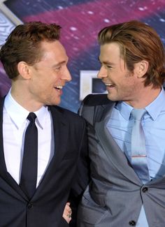 two men in suits are smiling together at the red carpet event for the avengers age of ultron