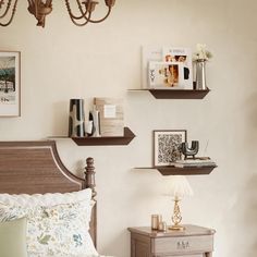 a bed room with a neatly made bed and two shelves on the wall above it