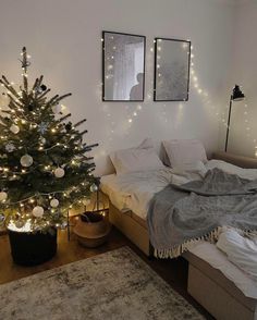 a bedroom decorated for christmas with lights on the walls and a small tree in the corner