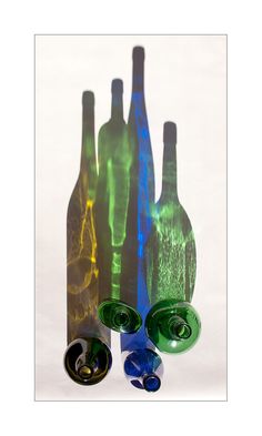 three wine bottles with different colored lights in them