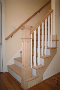 the stairs are made of wood and have white railings