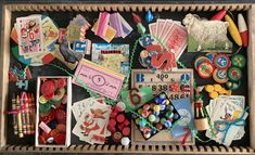 a wooden box filled with lots of different types of crafts and decorations on top of a table