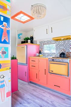 the kitchen is brightly colored and has an interesting light fixture in it's center