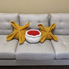 a crocheted starfish sits next to a bowl on a couch