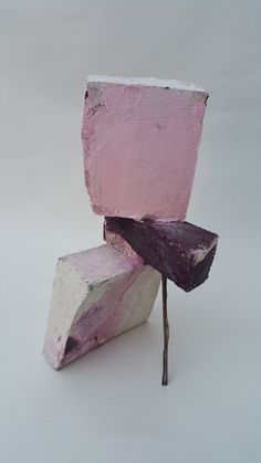 two pieces of pink and white are stacked on top of each other with sticks sticking out of them