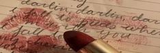 a close up of a lipstick on top of a piece of paper with writing on it