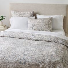 a bed with white linens and pillows on it