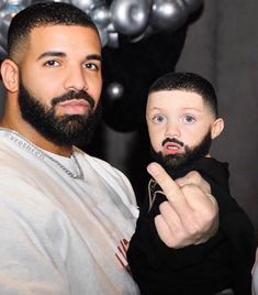 a man holding a small child in front of silver balloons with the word love on it