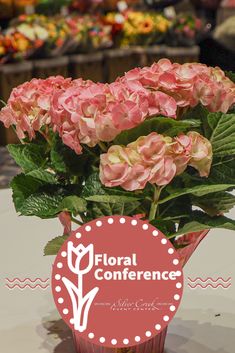 pink flowers in a vase on a table with the words floral conference above it and an orange circle that says,