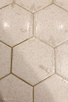 the corner of a white tiled bathroom floor