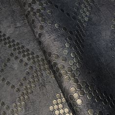 an upholstered black and gold fabric with hexagons on it's surface