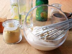 there is a mixing bowl with whisk and other ingredients in it on the table