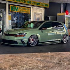 a green car parked in front of a store