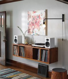 an entertainment center with bookshelves, speakers and a painting hanging on the wall