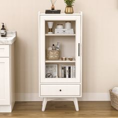 a white cabinet with books and magazines on it next to a sink in a room