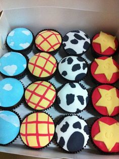 a box filled with cupcakes covered in frosting and decorated like cartoon characters