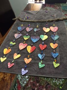 a table topped with lots of colorful hearts on top of a gray cloth covered in beads