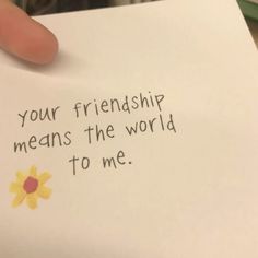 a hand holding a piece of paper that says, your friendship means the world to me