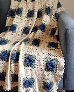 a crocheted blanket with blue flowers on it