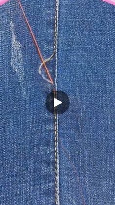 the sewing needle is being used to sew on denim fabric with pink trims