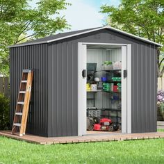 a storage shed with the door open and shelves full of items in front of it