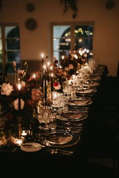 a long table is set with silverware and candles for an elegant dinnereon party