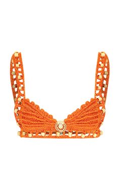an orange crochet bralet with gold buttons