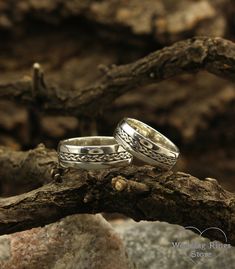 two wedding rings sitting on top of a tree branch