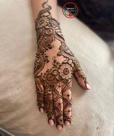 a woman's hand is decorated with hennap and intricate designs on it