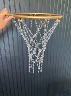 a person is holding up a chandelier in front of a door that has beads hanging from it