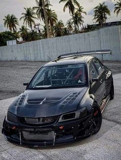 a black car parked on top of a parking lot