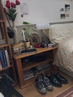 two pairs of shoes are on the floor in front of a bed and bookshelf