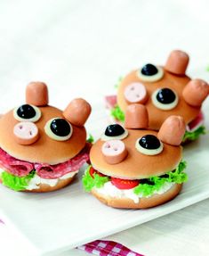 some very cute looking sandwiches on a white plate with eyeballs in the shape of pigs