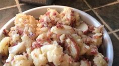 a white bowl filled with potatoes on top of a table