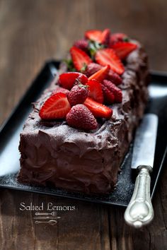 there is a chocolate cake with strawberries on it