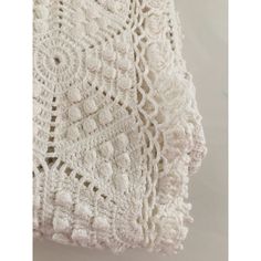 a white crocheted blanket hanging on a wall