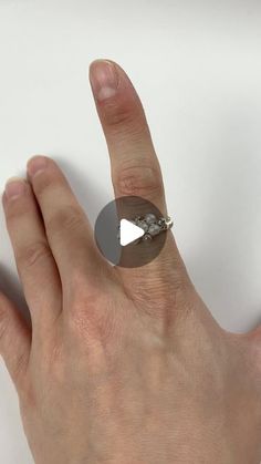 a person's hand with a ring on it that has a triangle in the middle