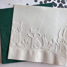two napkins with animals on them sitting next to each other