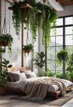 a bedroom with plants hanging from the ceiling and bed in front of a large window