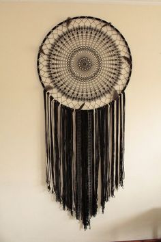 a black and white dream catcher hanging on the wall